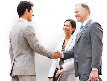 Two businessmen shake hands while businesswoman watches.